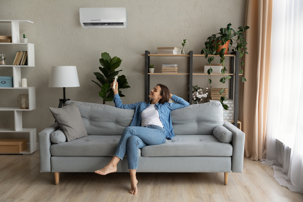 woman operating a ductless mini split with a remote